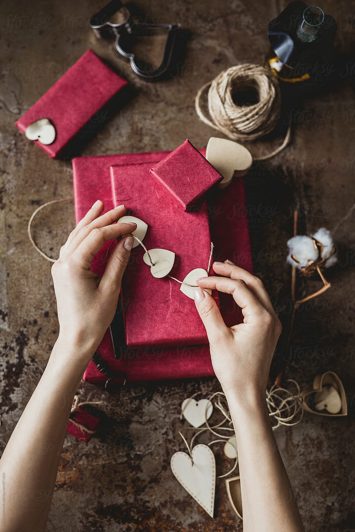 Hands wrapping gifts for Valentine\'s Day