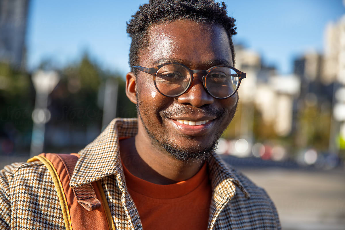 Portrait of man in glasses and checked shirt on bright sunny day