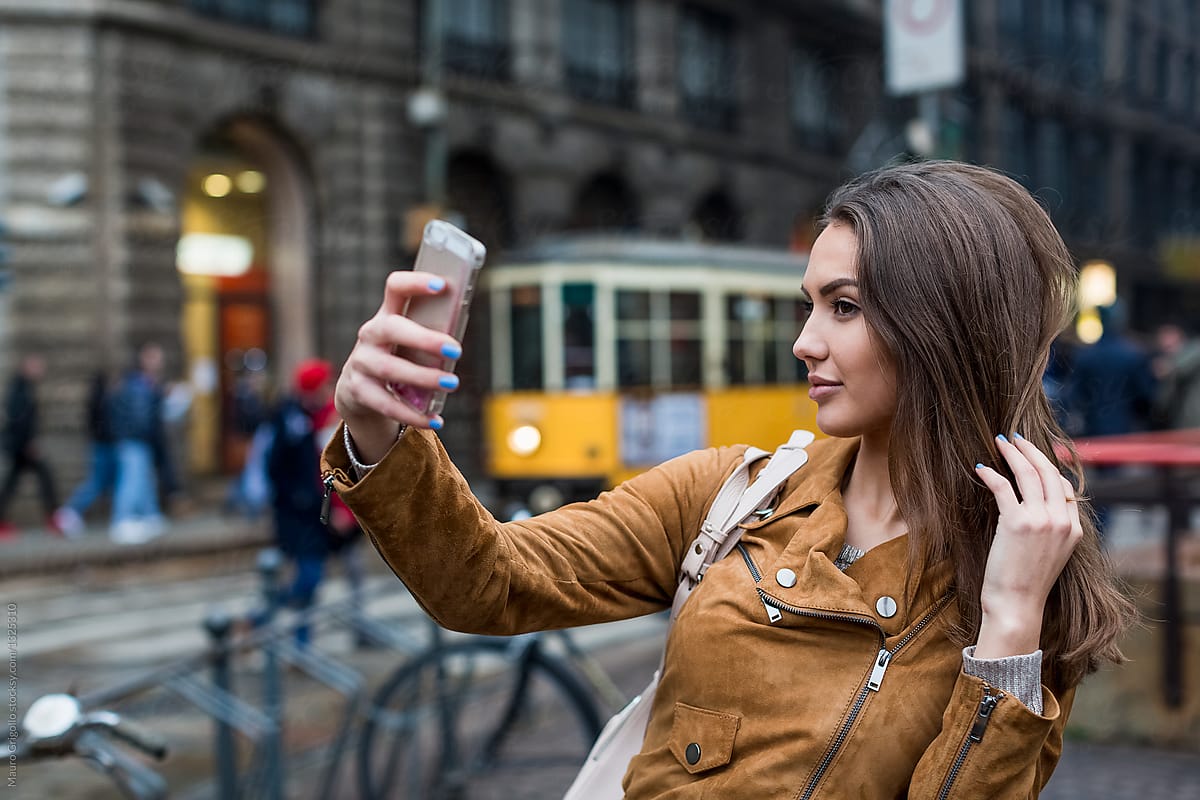 A woman takes a selfie with a mobile phone