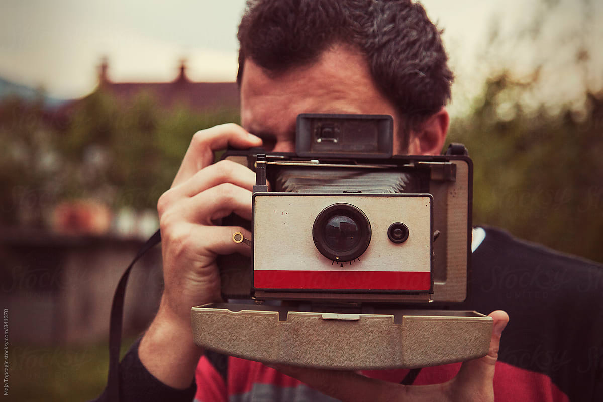 Man taking a photo with an old vintage film camera