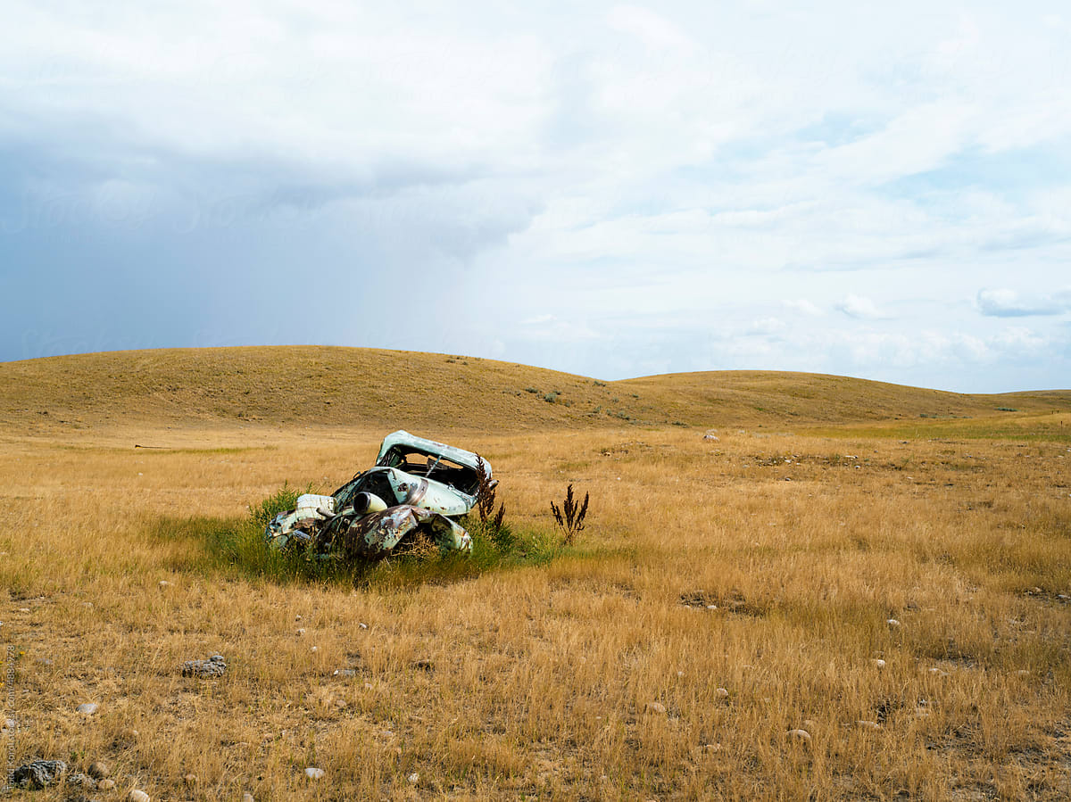 An old car on native prairie grasslands in the summer.