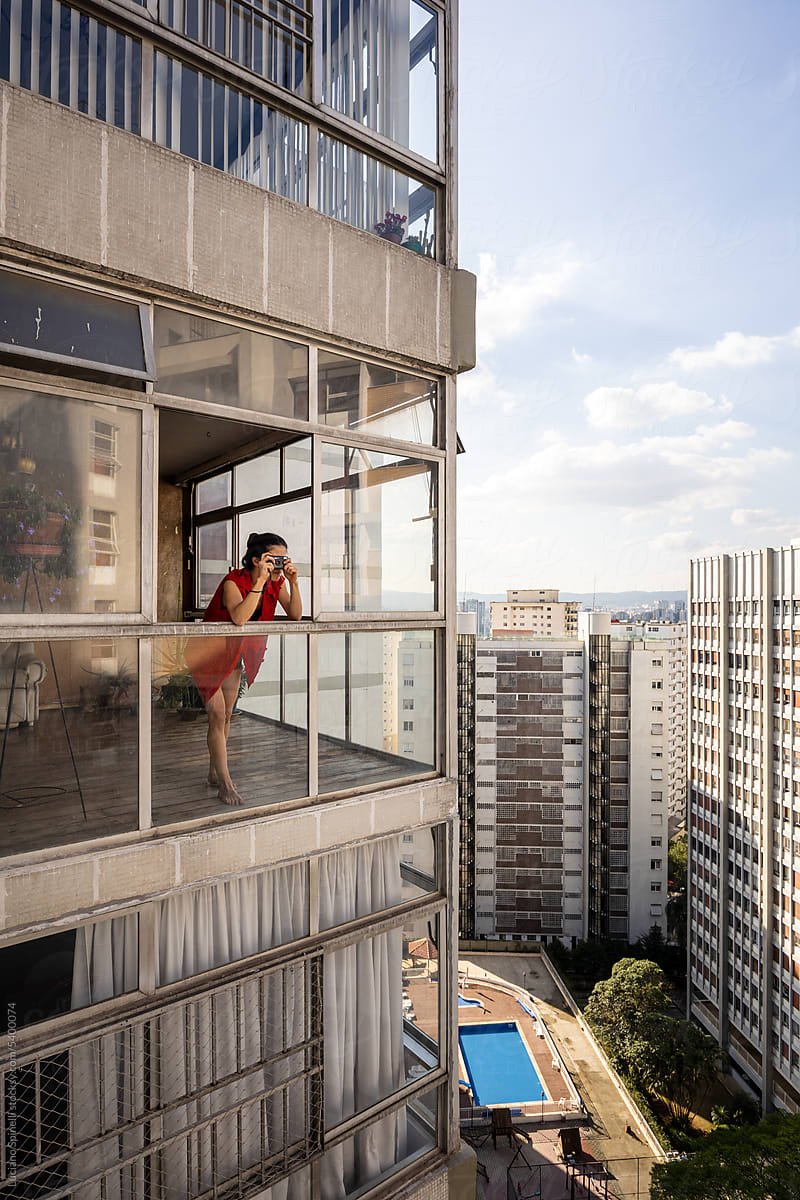 Urban voyeur woman watching her neighbours from panoramic window
