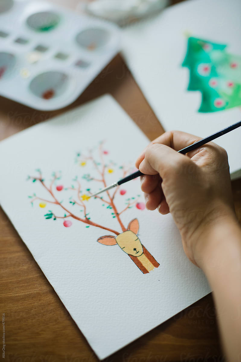Hand holding brush painting DIY Christmas card
