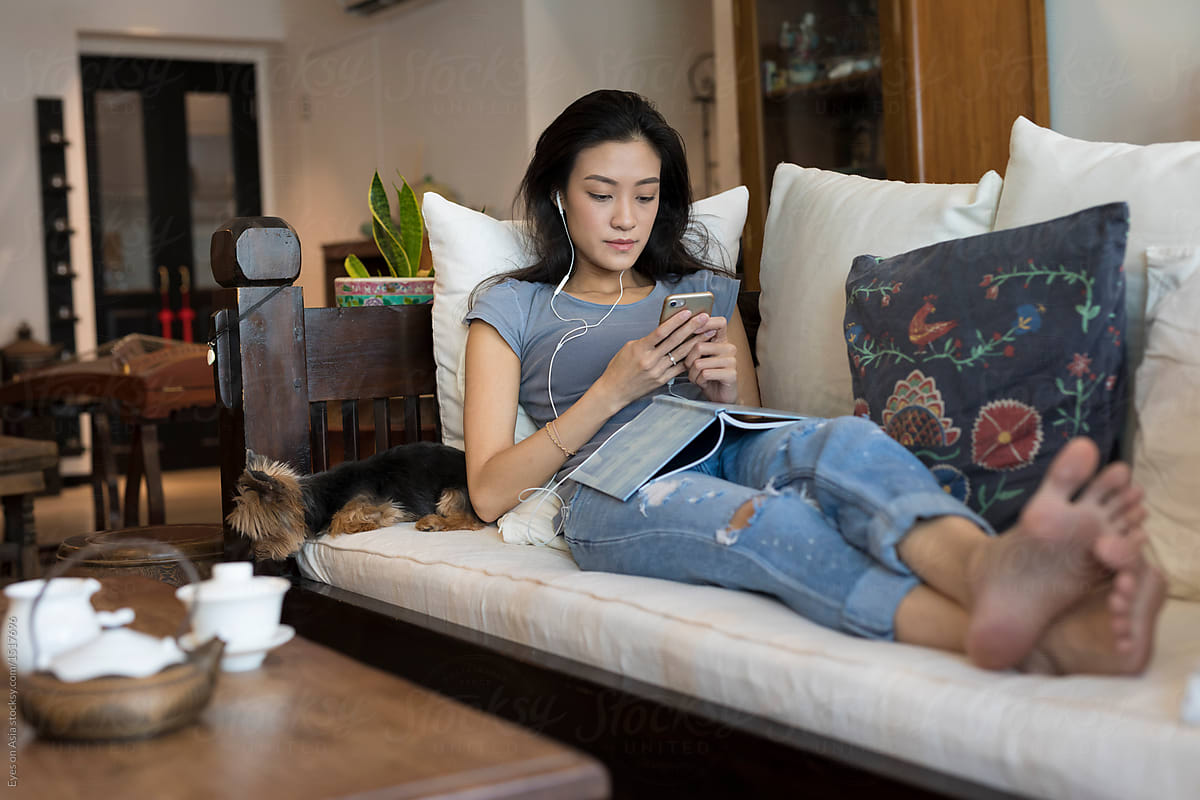 Singaporean woman on her sofa texting
