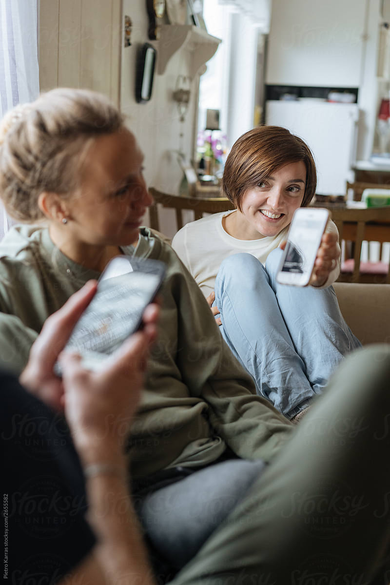 Woman showing smartphone screen to friends