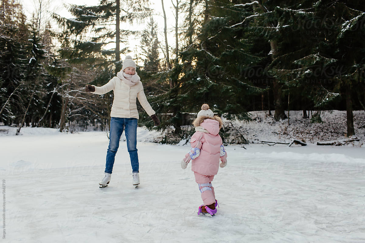 Child with mom having fun skating on ice