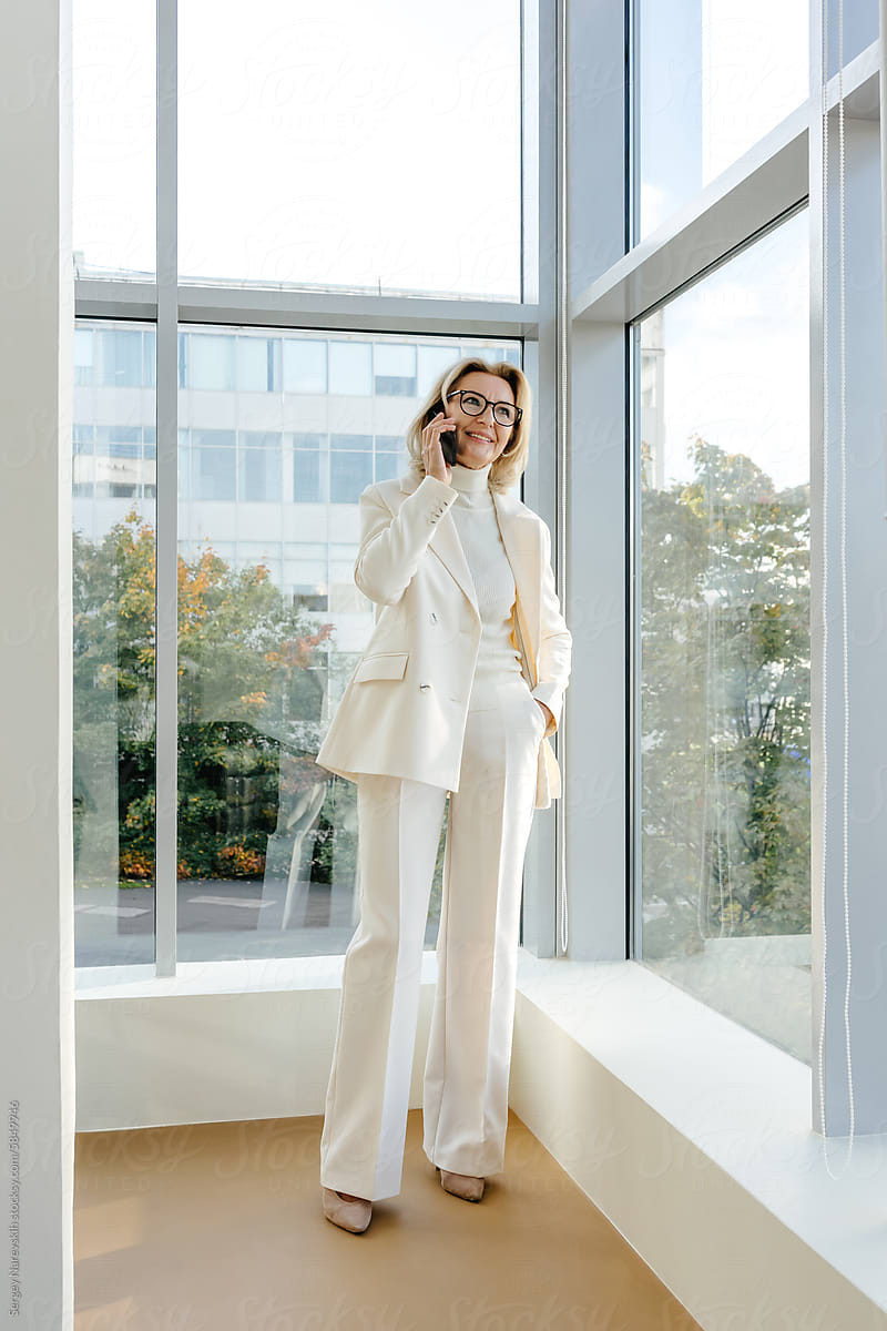 Elegant businesswoman with smartphone in modern office