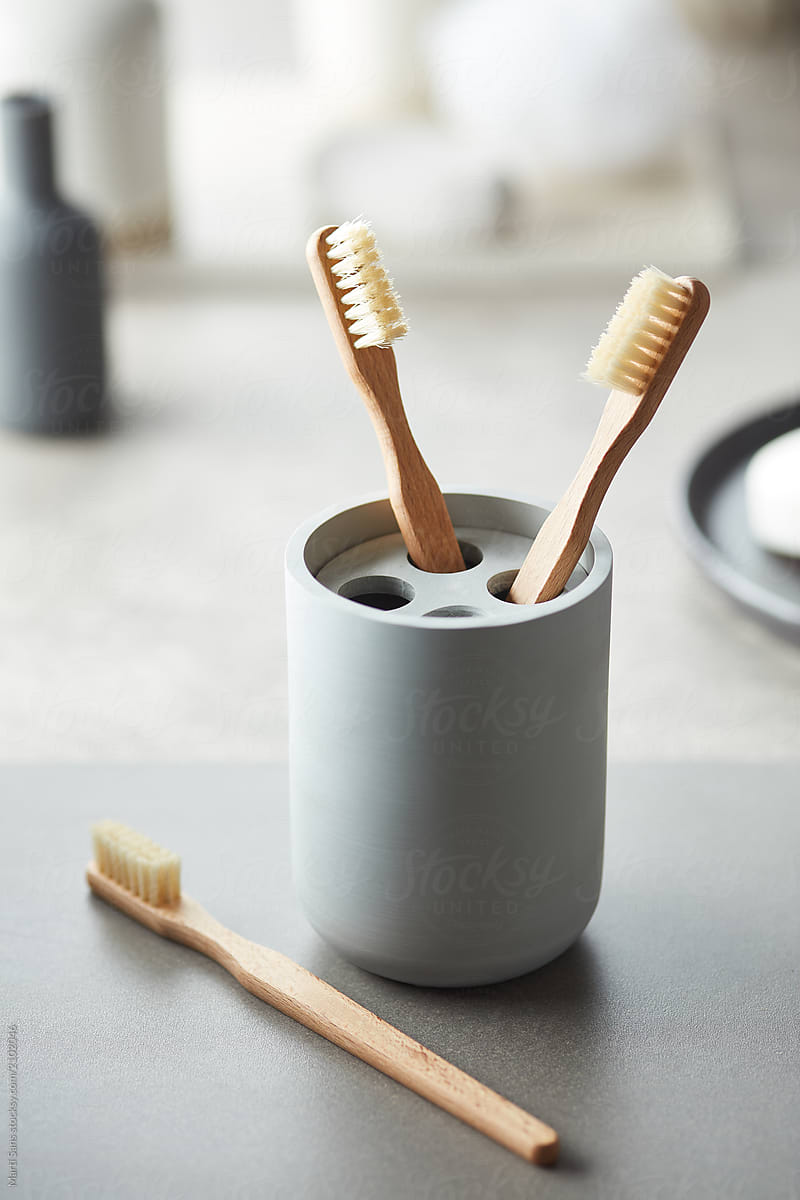 Ceramic bath holder with bamboo toothbrushes.