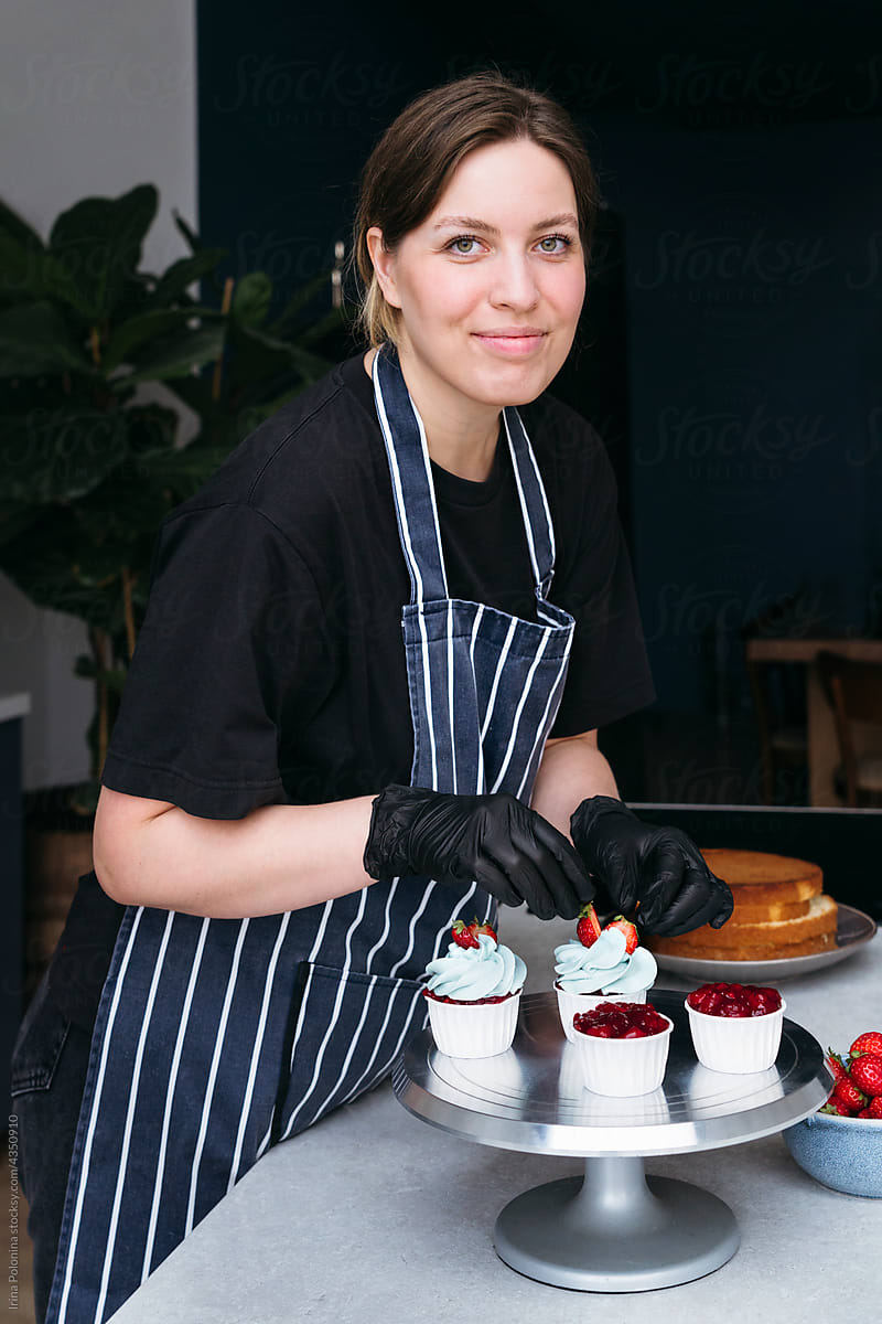 Woman Pastry Chef Preparing Red Batter Muffins To Bake by Stocksy