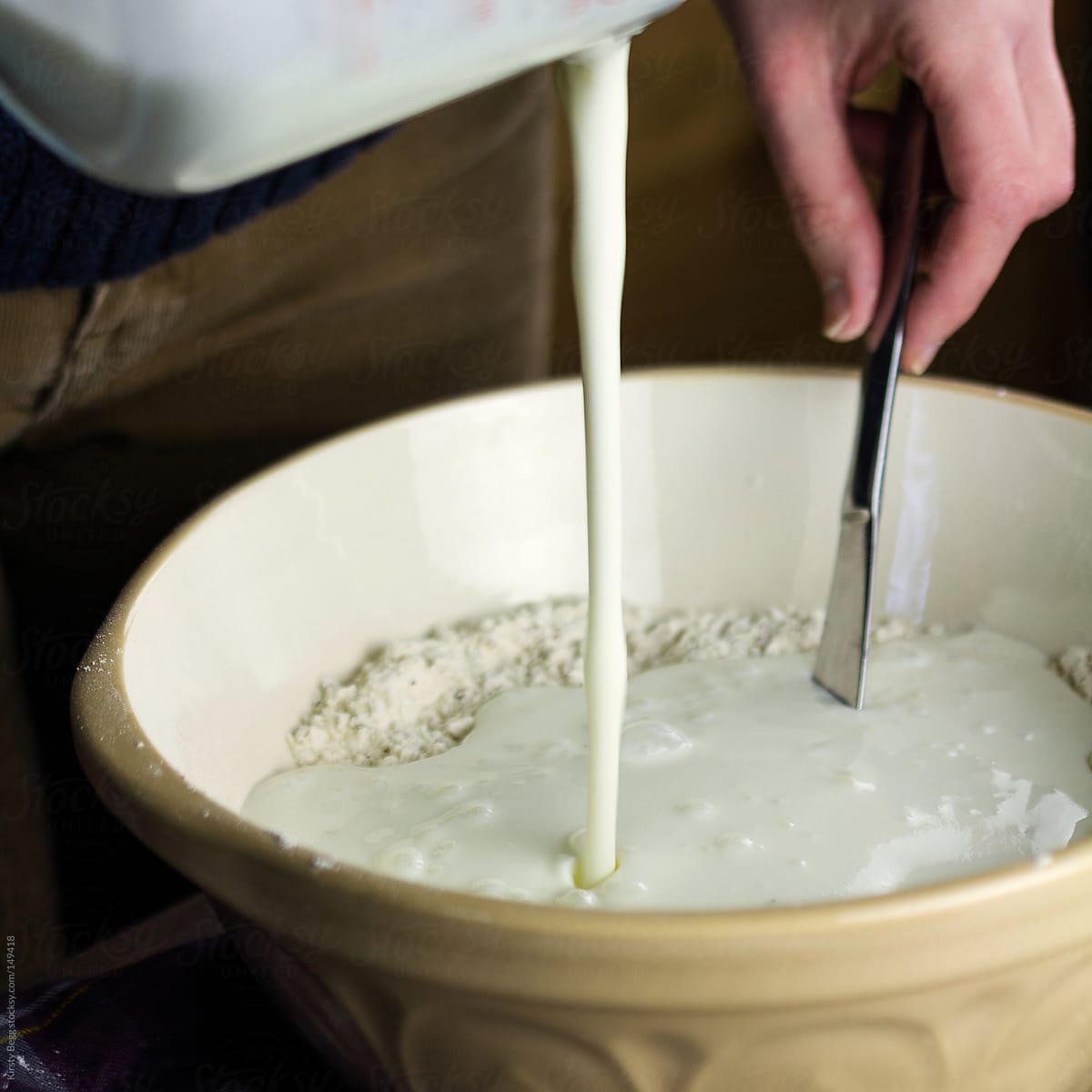 Woman pouring buttermilk mixture into flour