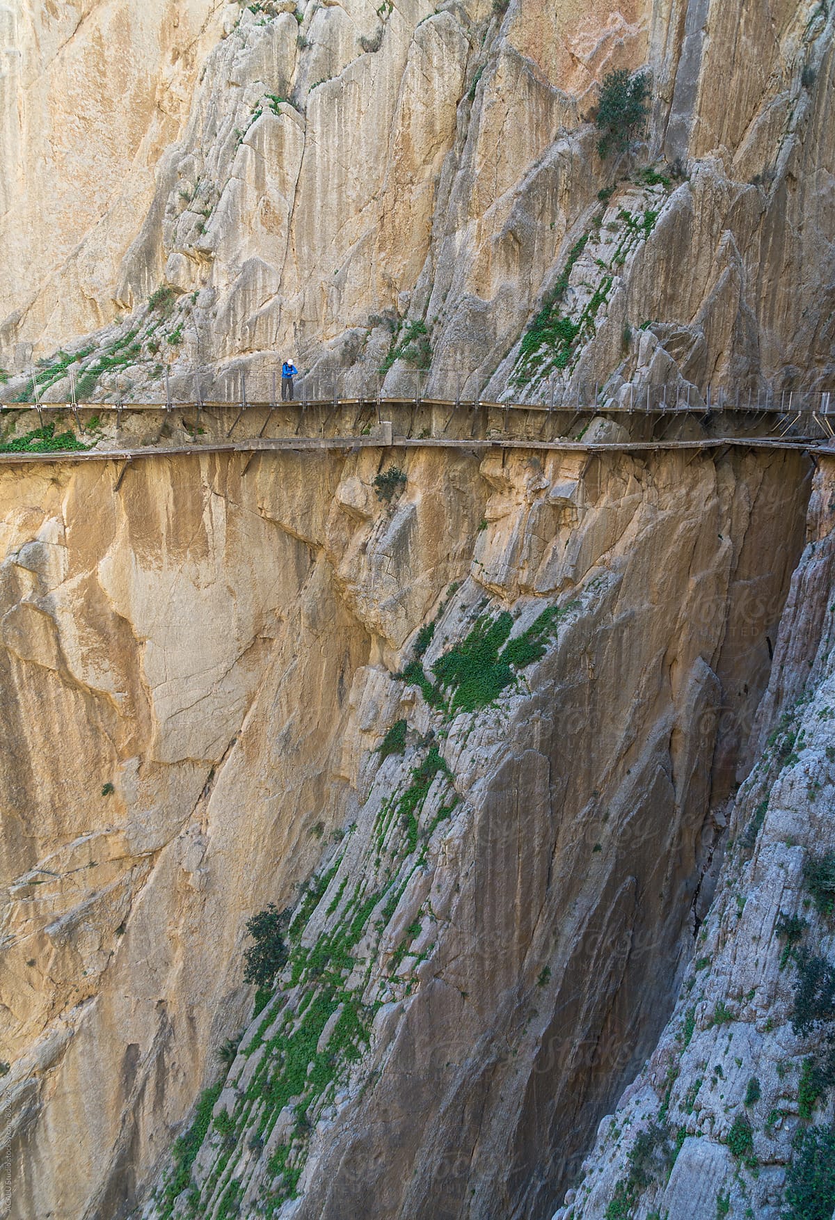 Hiker looking down at the edge of a cliff in Caminito del Rey