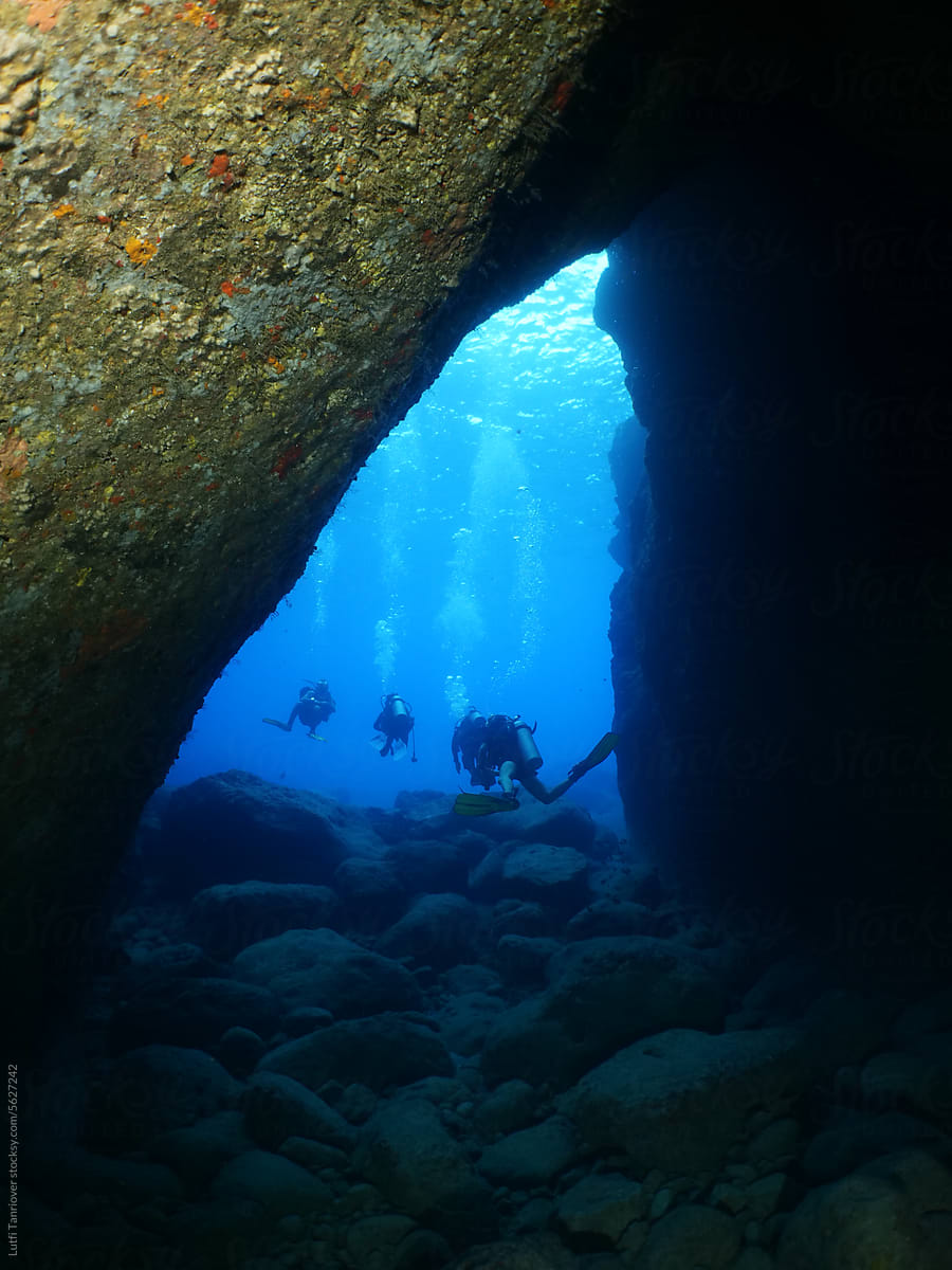 cave diving underwater scuba divers exploring caves