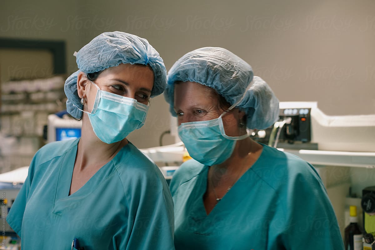 Smiling female hospital workers full surgical wear in operation room