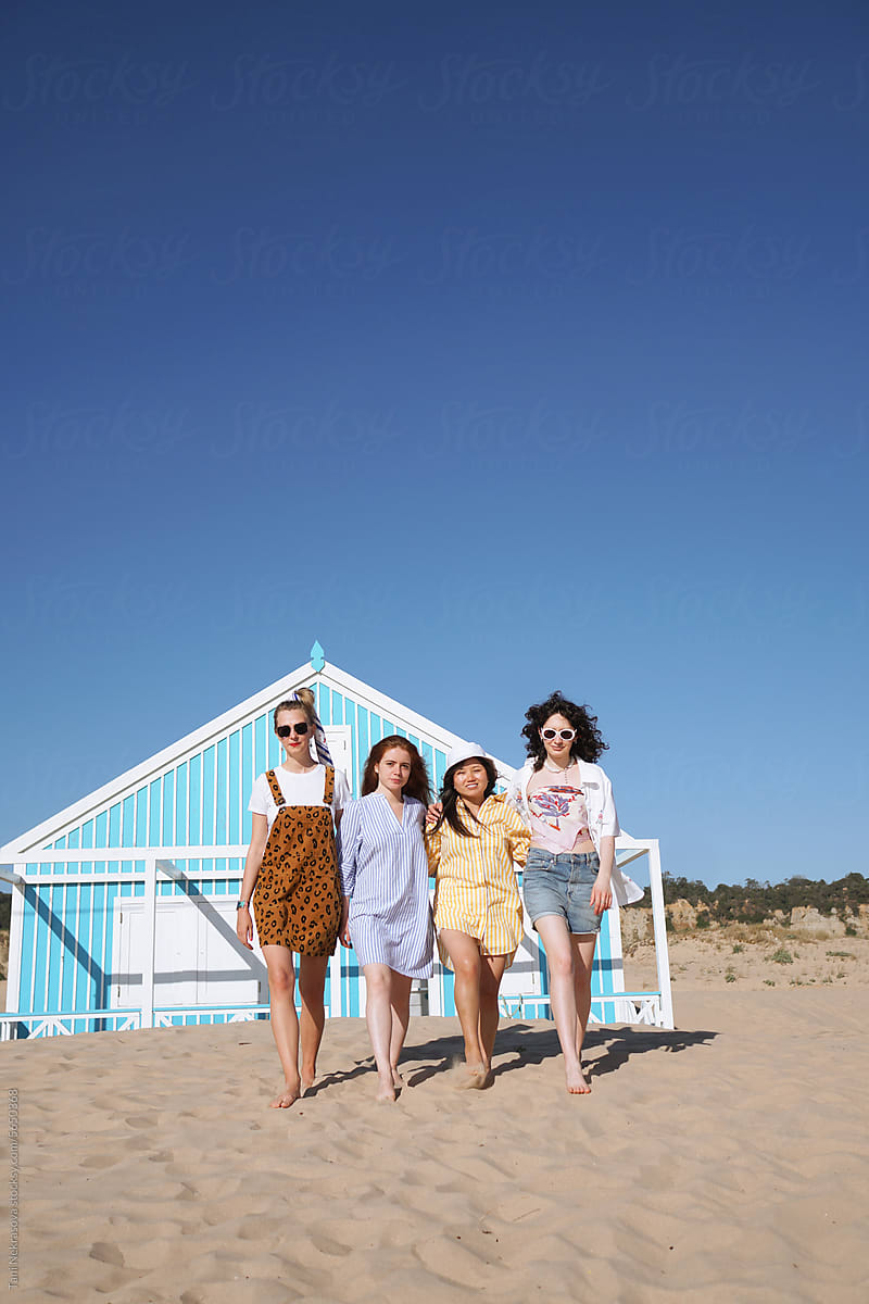Four young female friends traveling together by the ocean. Feminism