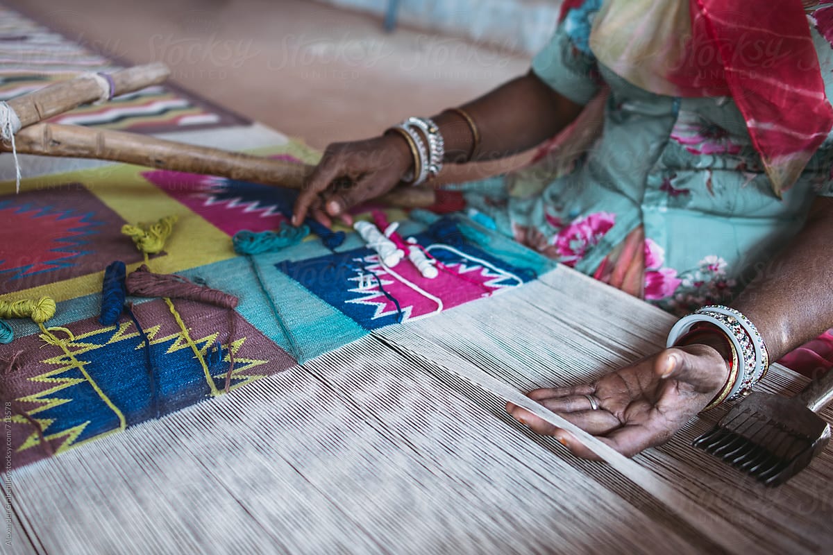 Indian woman weaves traditional carpet