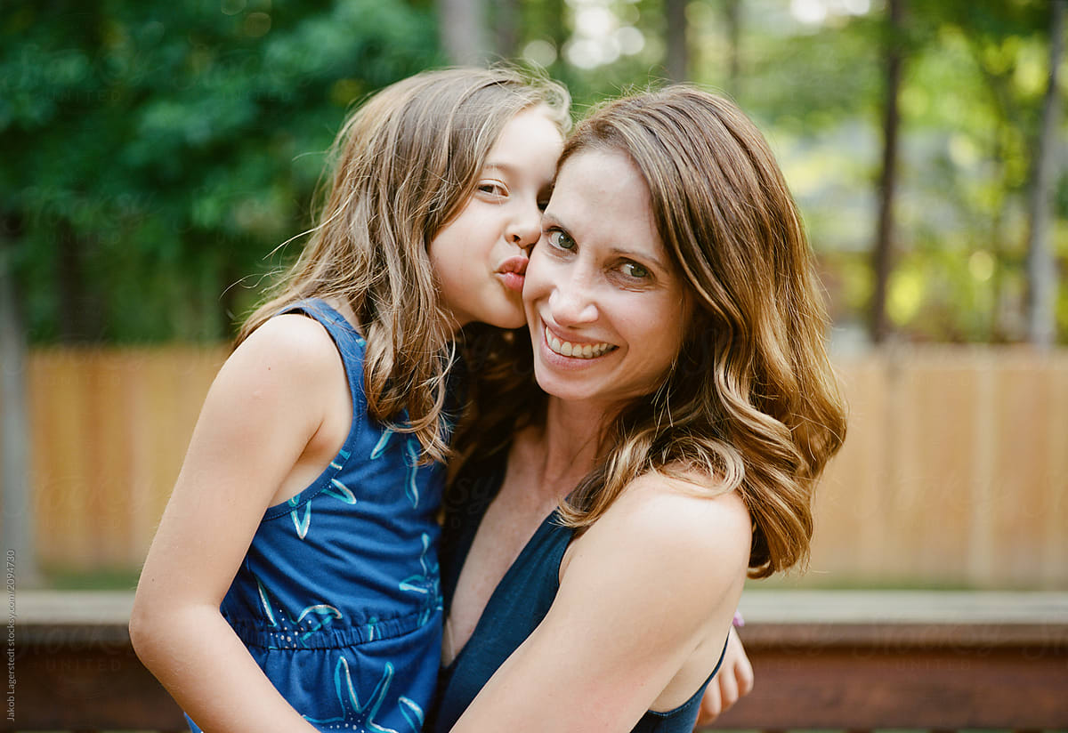Daughter kissing mother's cheek. 