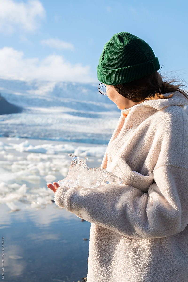 Woman Holding Melting Glacier Ice. Human interaction with nature