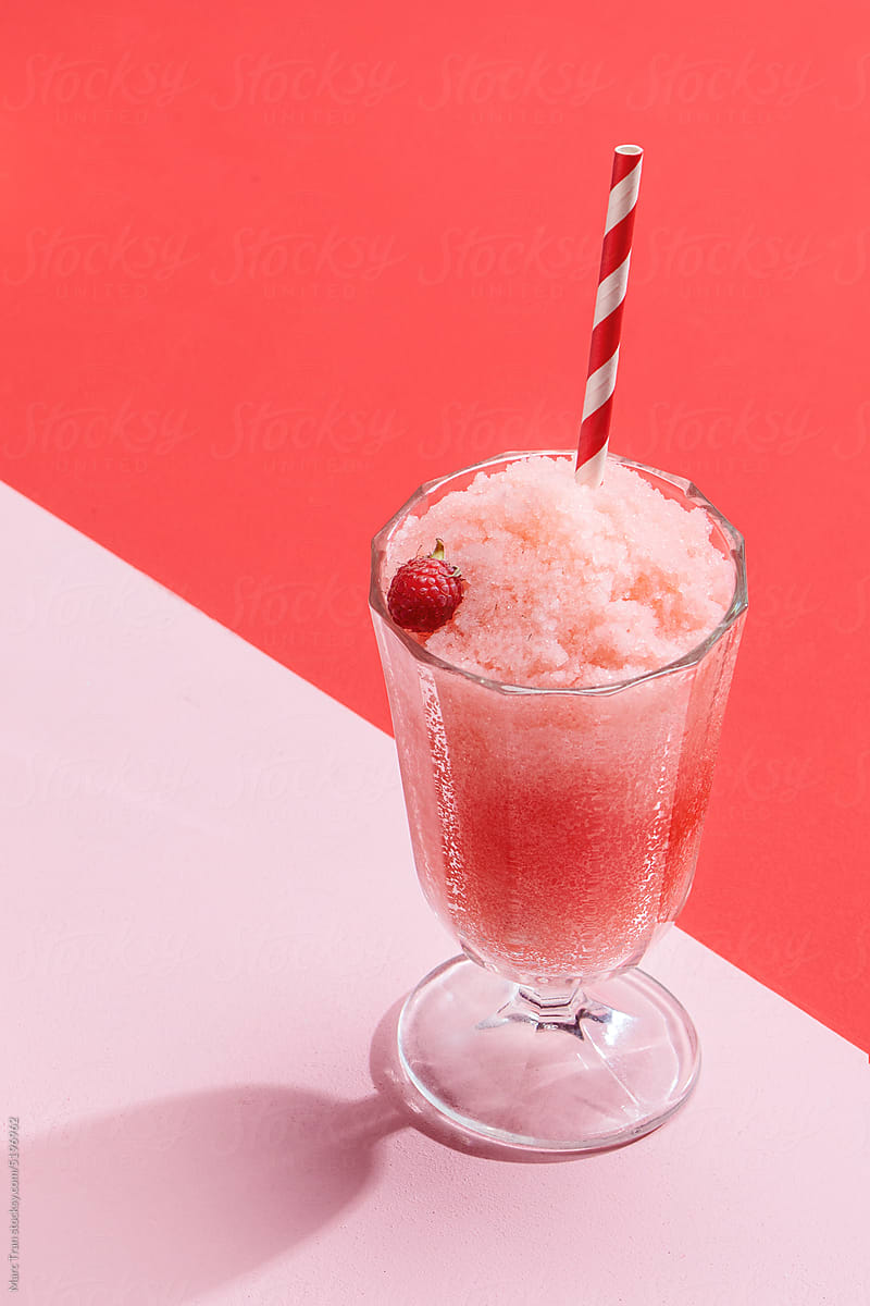 Pink Background with a strawberry smoothie in a cocktail glass