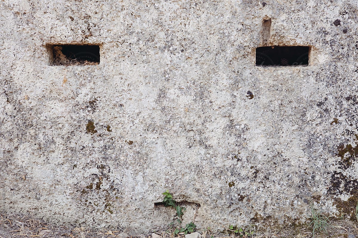 Small windows on wall shaped human face.