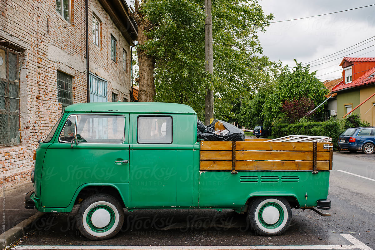 Small green truck parked on a street