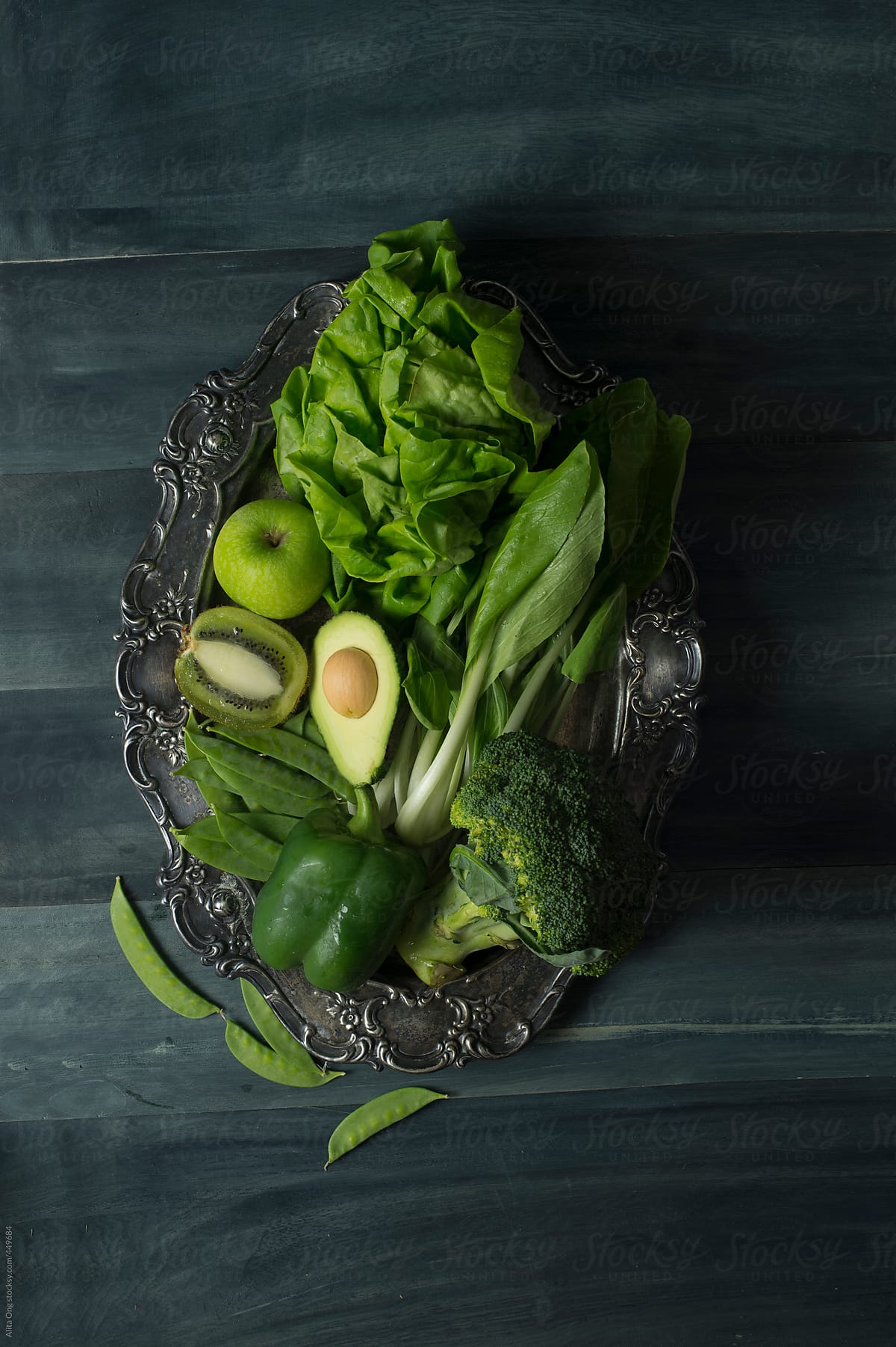 Green fruits and vegetables on rustic metal tray