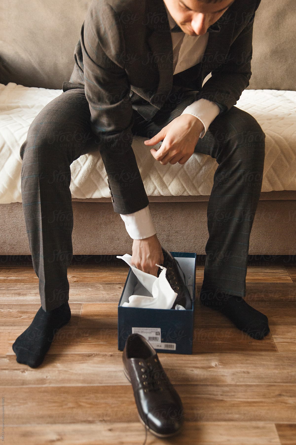 Man in suit taking out new shoes