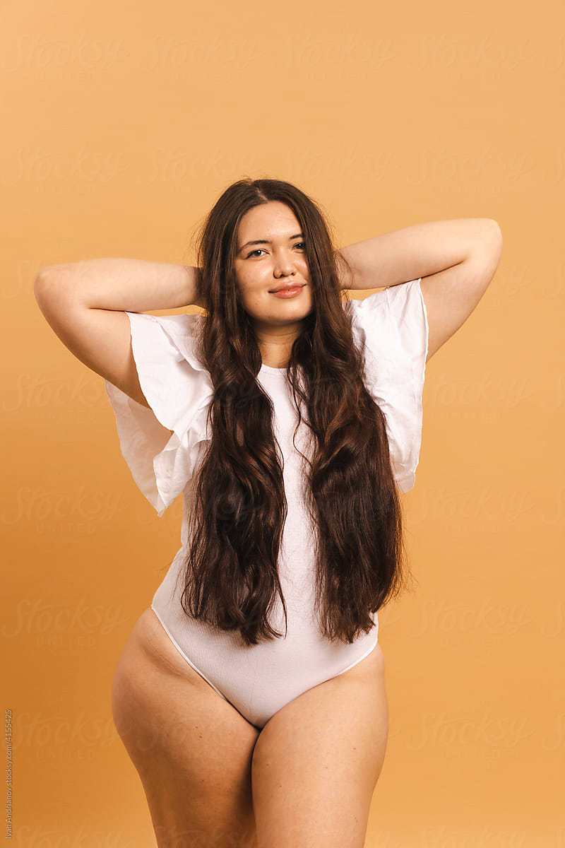 Beautiful plus size smiling young woman in a studio