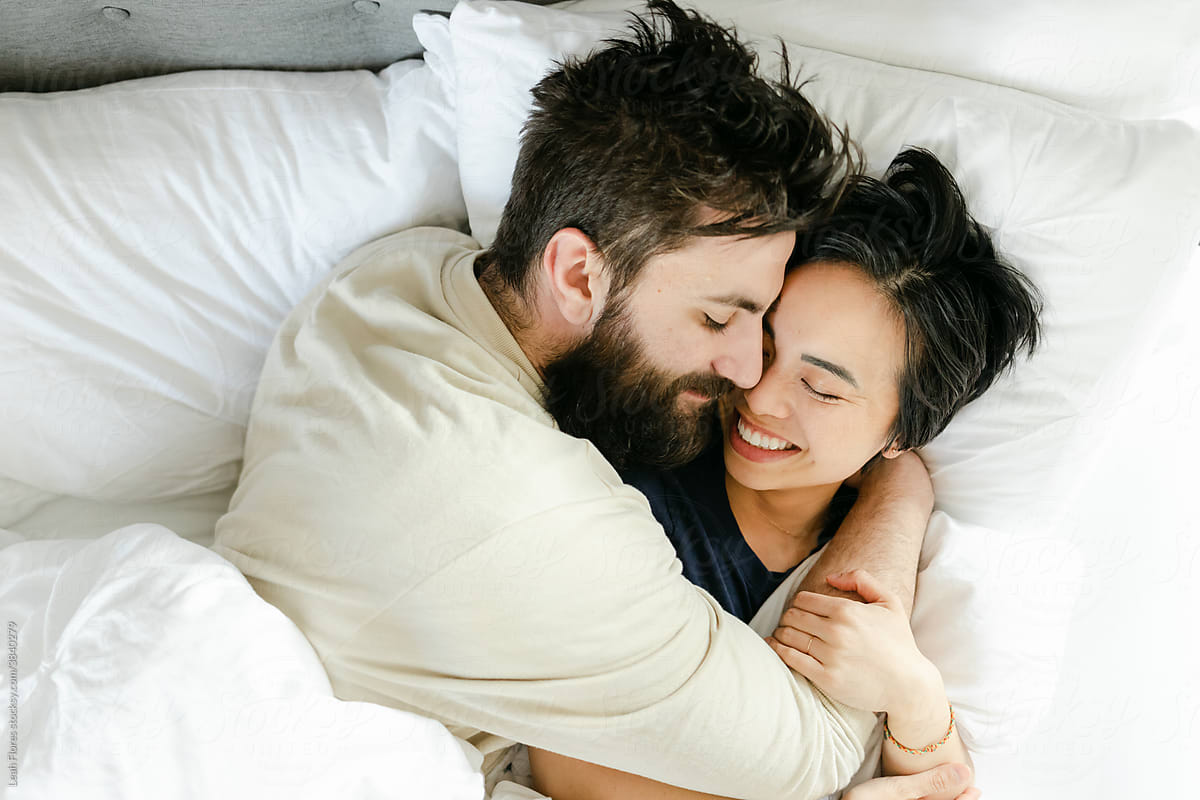 Happy Couple Snuggling In Bed By Stocksy Contributor Leah Flores Stocksy