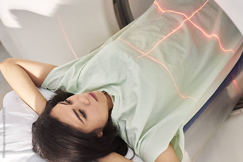 Young female patient with arms behind her head for abdomen tomography