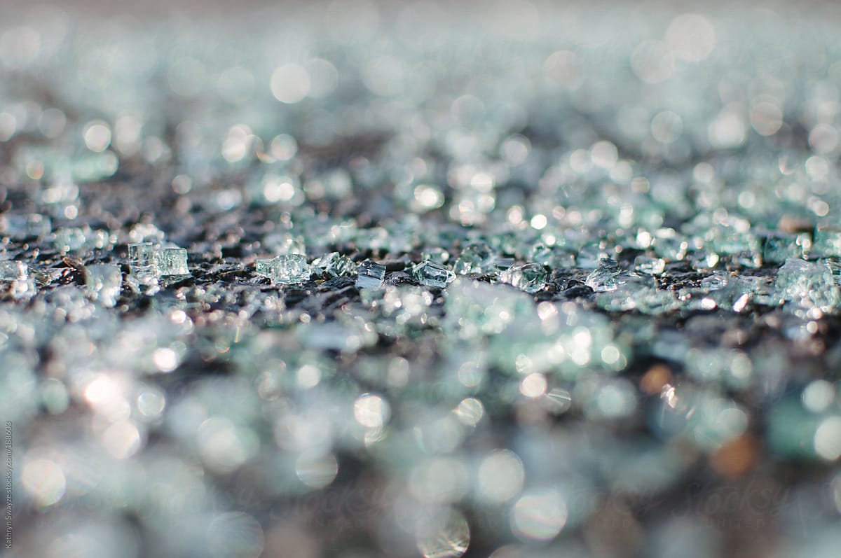 Close-up of shattered windshield glass on pavement