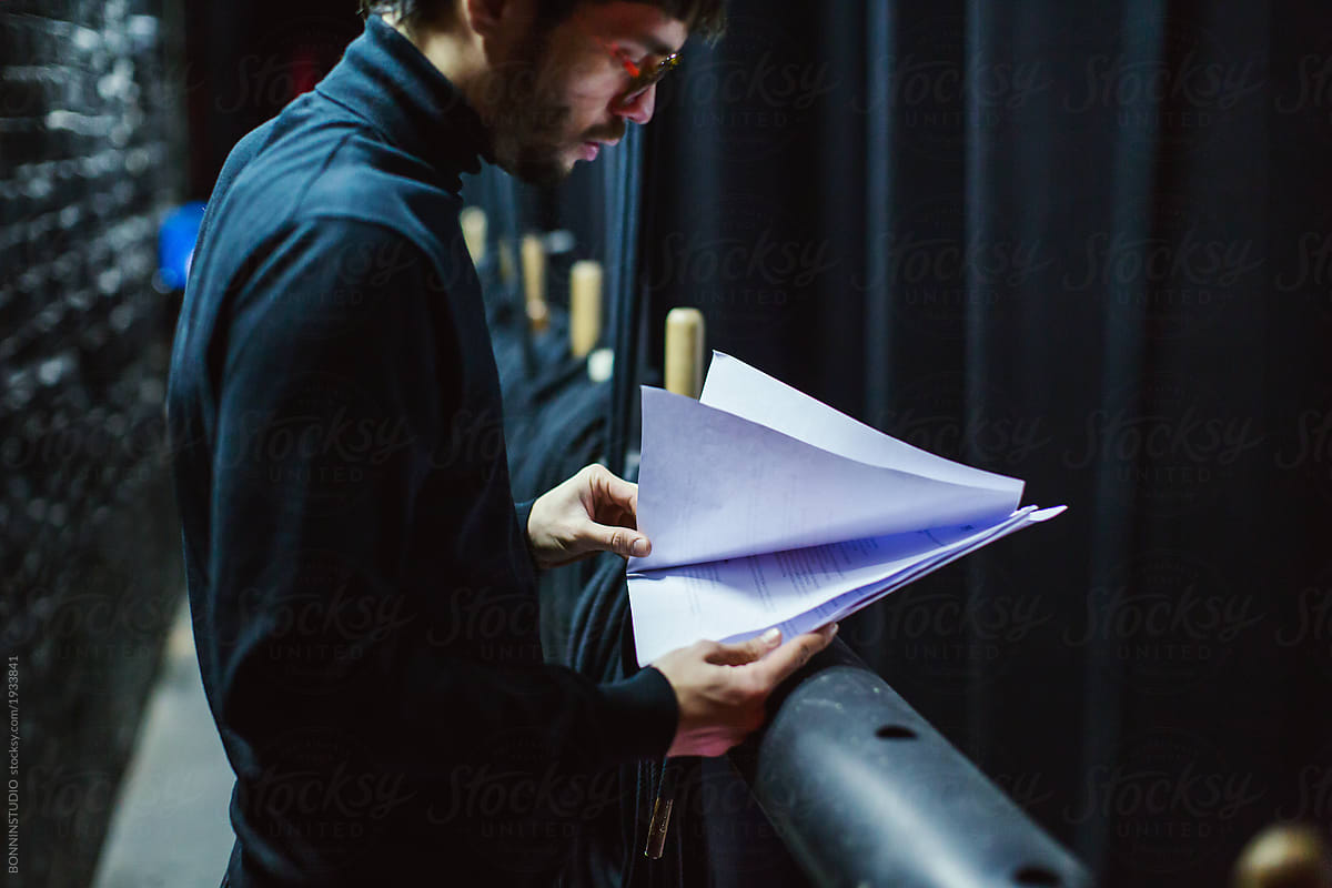 Actor reviewing script in theatre.