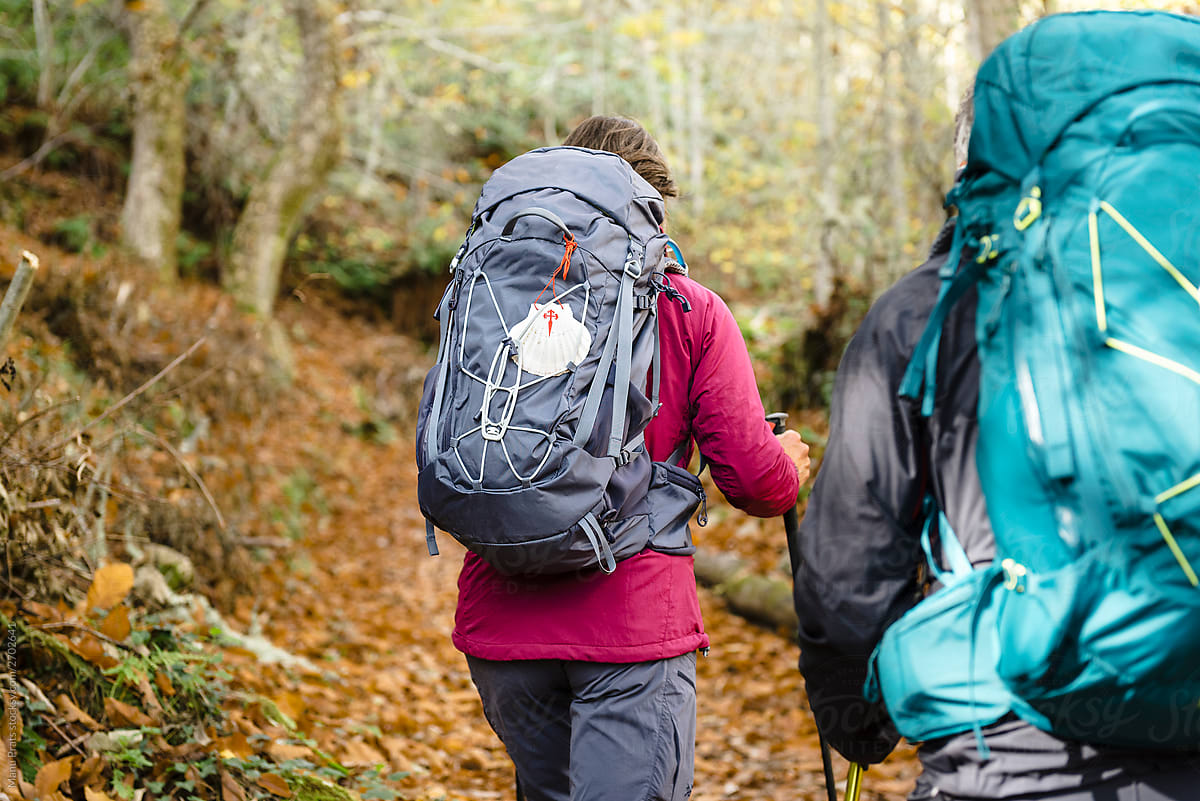 Adult sportsman and adult sportswoman hiking together