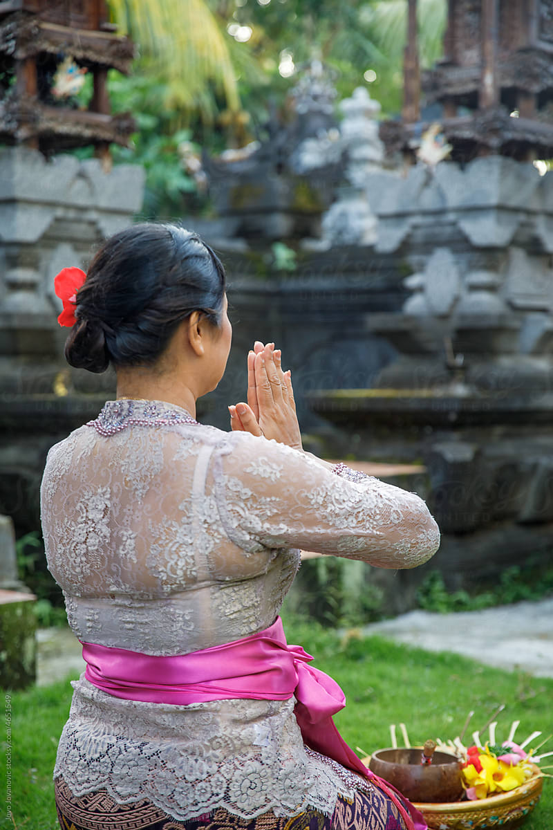 Balinese woman praying in the family Hindu temple