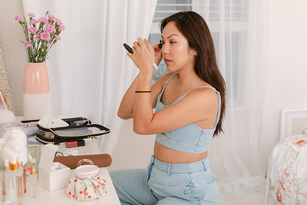 Asian Woman Doing Makeup at Vanity