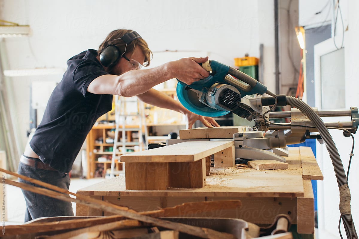 Young Male Carpenter Using Circular Saw in Bright Workshop