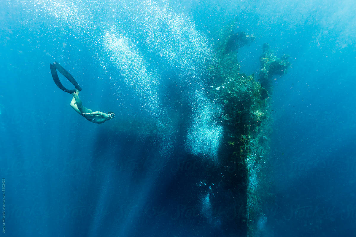Apnea diver diving around sunken ship