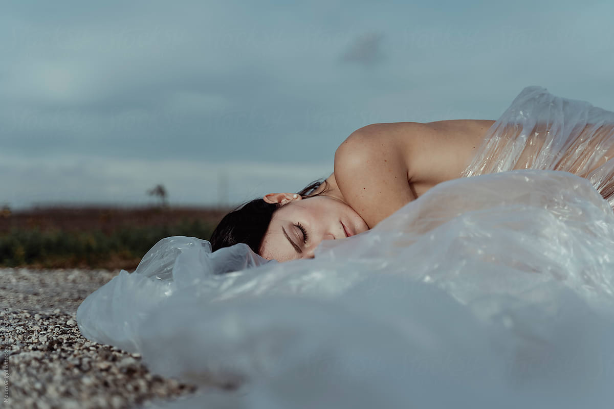 Woman covered with cellophane sleeping on the ground