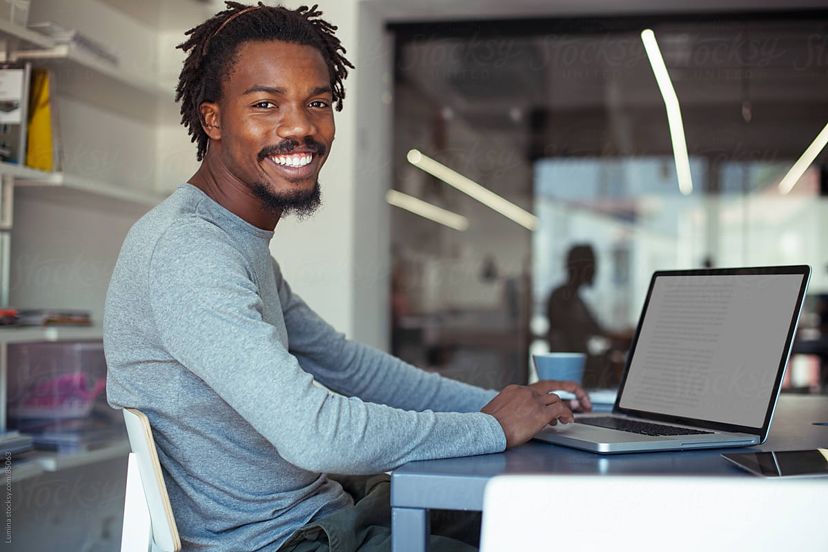 Smiling African Businessman at His Laptop