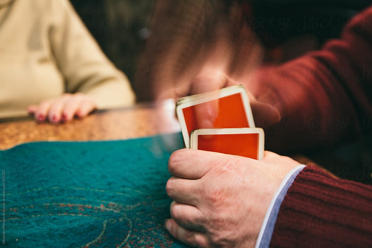 Man shuffling deck of cards playing poker game
