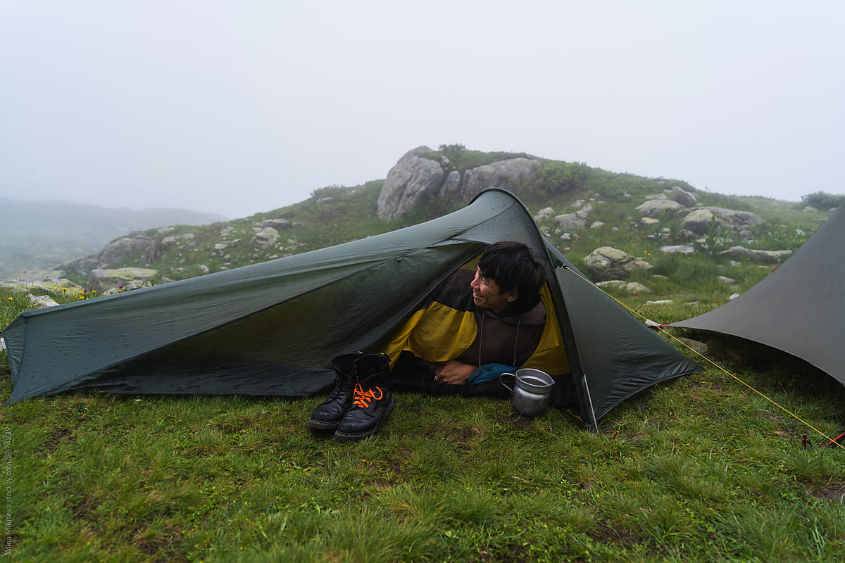 Man In Camping Tent On Foggy Day In Mountains