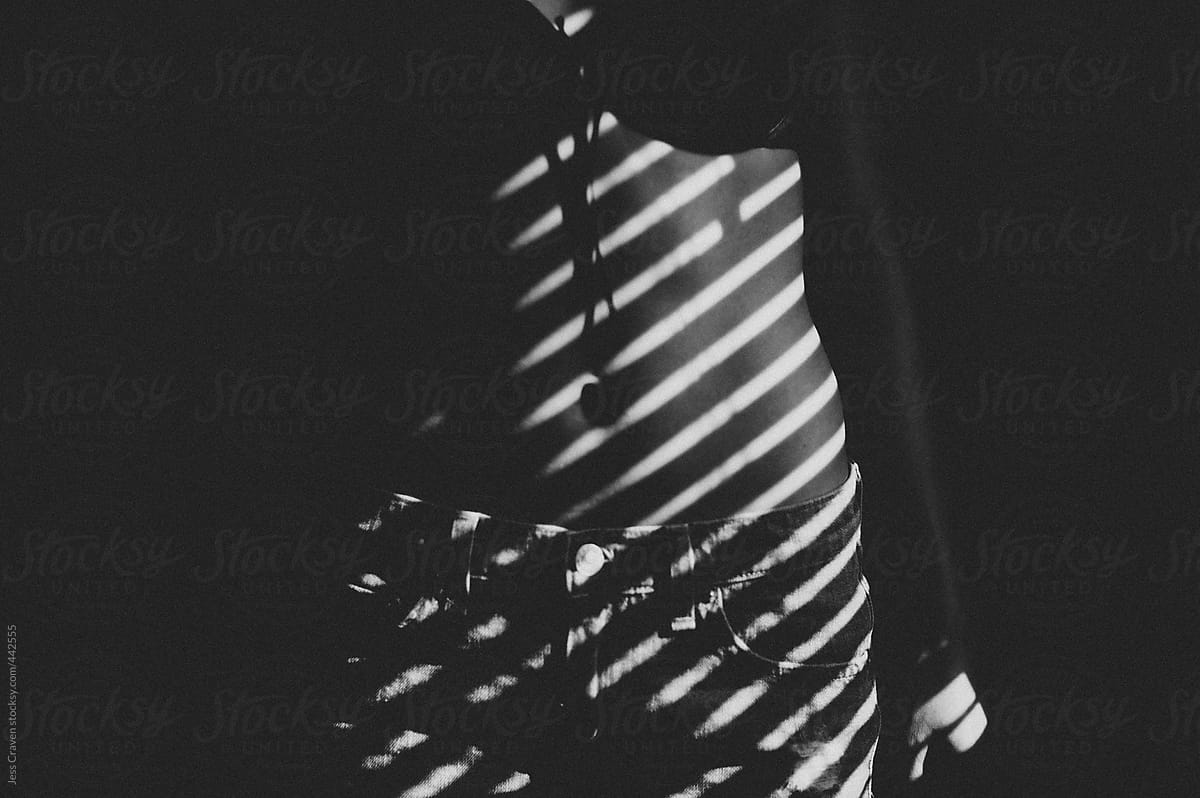 Window Blinds Shadow Lines On Woman's Stomach by Stocksy