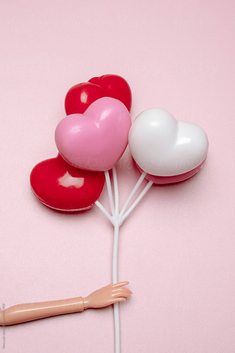 Holding heart-shaped balloons