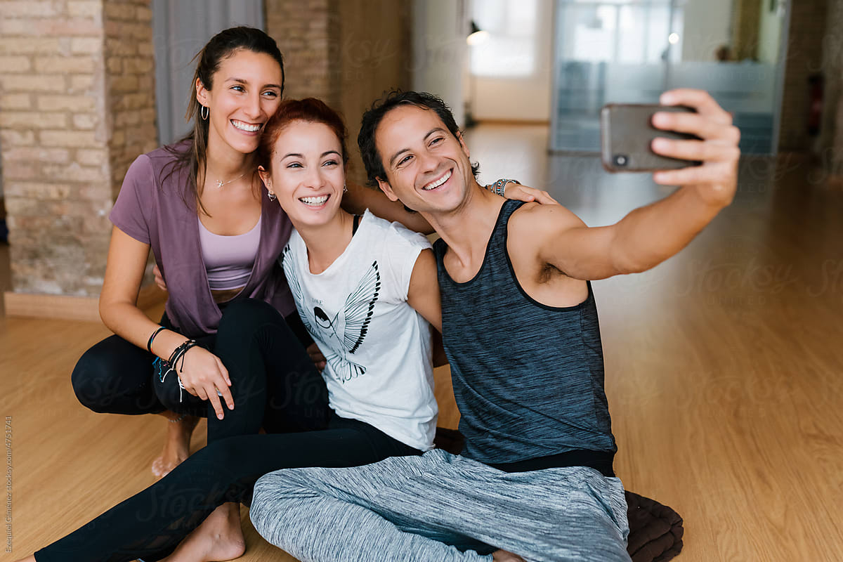 Joyful people taking selfie during yoga lesson