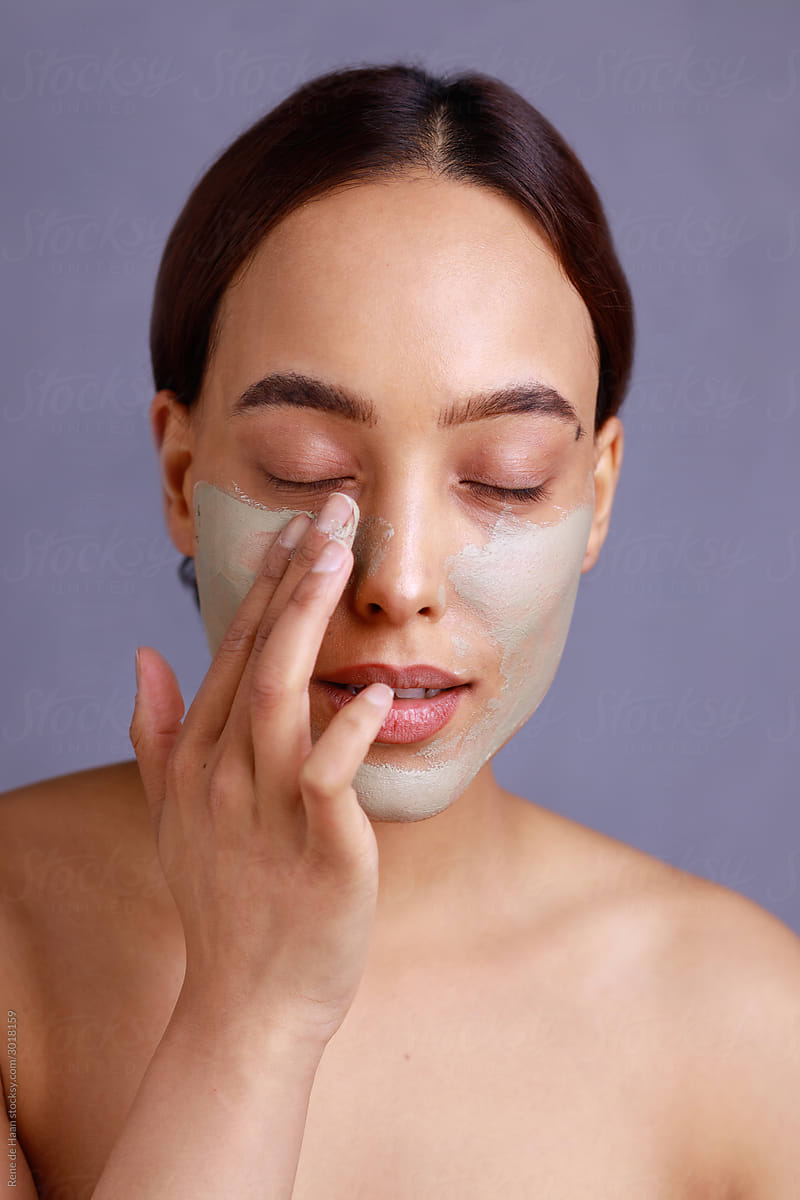 woman applying facial mask