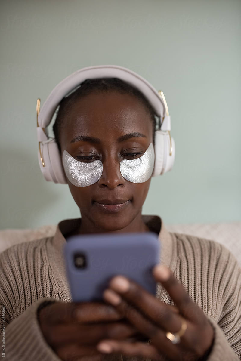 Black woman with eye patches listening to music