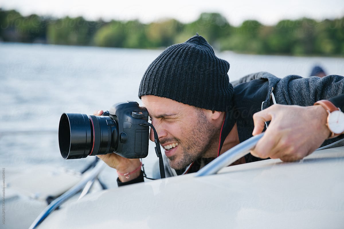 Portrait of Male Photographer Shooting With Digital DSLR Camera on Boat