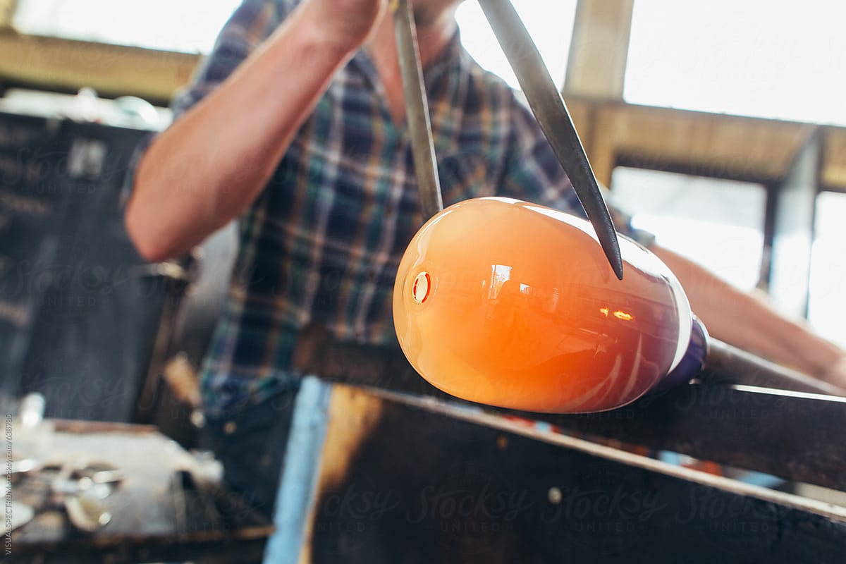 Artisan Glass Workshop - Close Up of Young Male Artist Working Glowing Hot Glass With Jacks