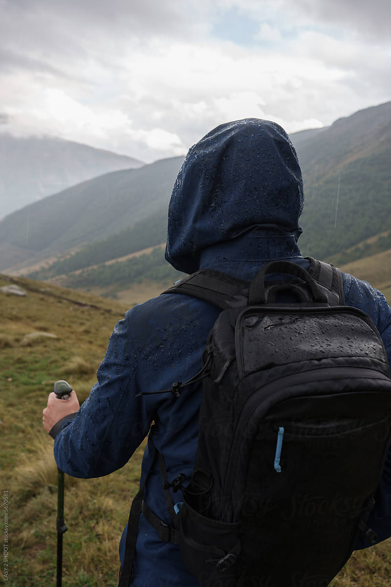 Mountain Hiker Wears Backpack at Stunning Landscape with Dramatic Sky