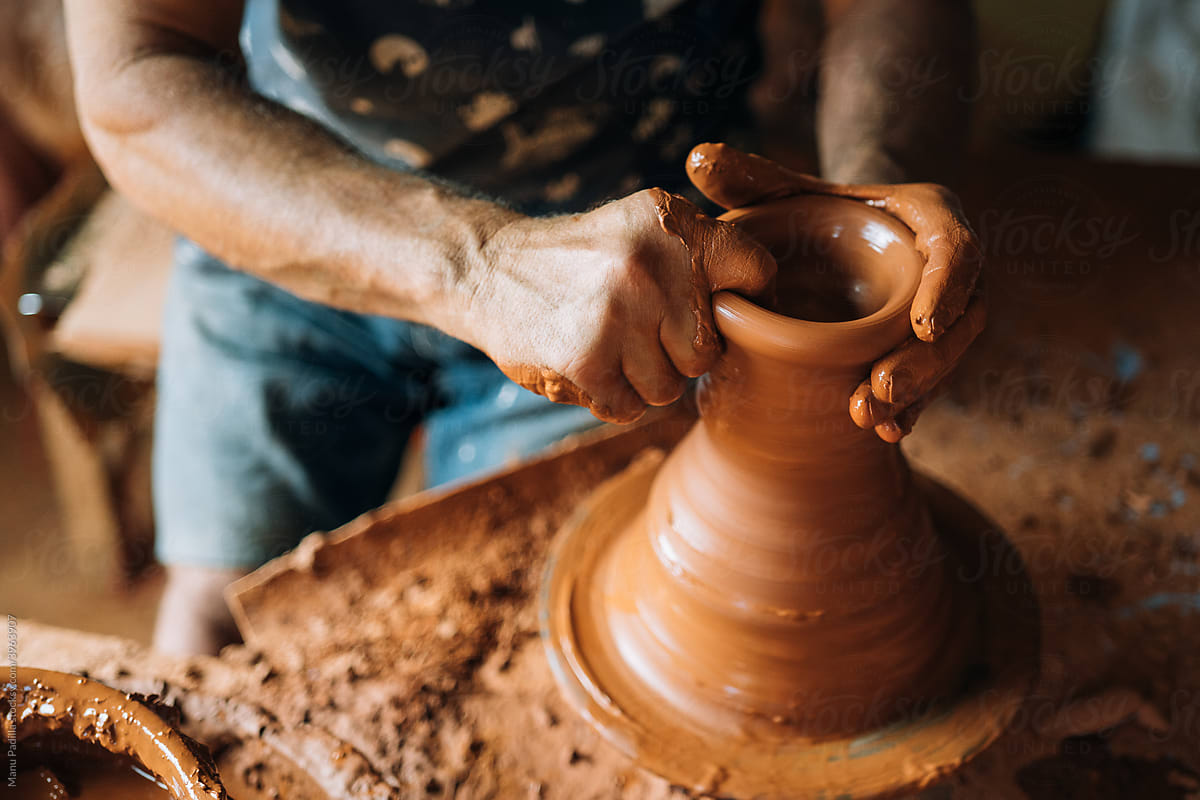 Man Works with his Hands in a Vase