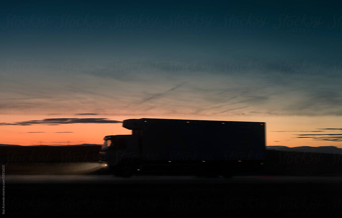 Truck driving on the road at sunset